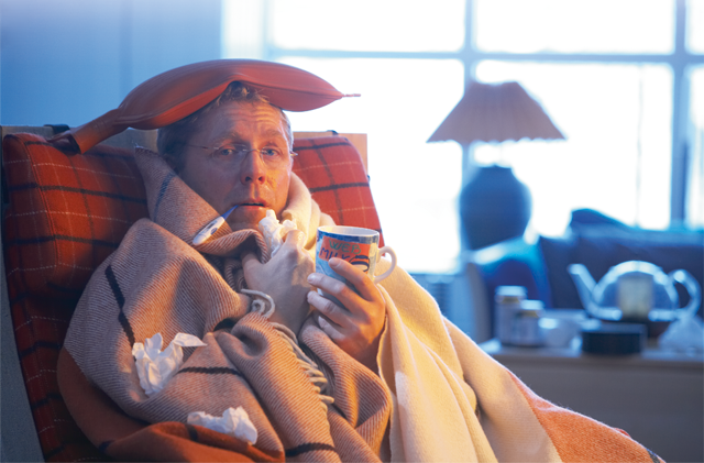 Symptomatic man is sitting in an armchair with a cup of tea